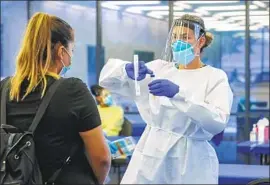  ?? I rfan Khan Los Angeles Times ?? NURSE Elizabeth McKinnon prepares Glenda Guerra for a coronaviru­s test at the Ontario Convention Center in July. Use of rapid tests has been fast expanding.