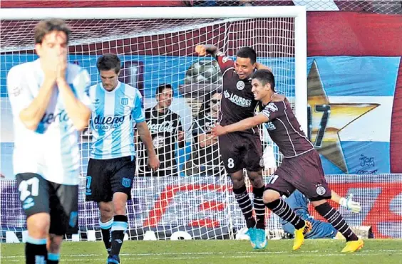  ?? / MARCELO CARROLL ?? Las dos caras. Hauche y Zuculini se lamentan mientras Barrientos celebra su gol junto con Chamorro. Racing, en caída libre. Lanús respira.