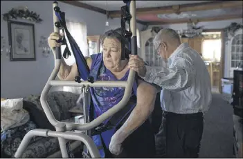  ?? PHOTOS BY THE NEW YORK TIMES ?? Larry TeSelle helps his wife, Beverly, who began to suffer vicious headaches that left her weeping and moaning after a second stroke and now takes a large amount of opioids for the pain, move into her wheelchair at their house in Milford, Neb. A...