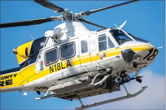  ?? (Above) Austin Dave/The Signal ?? (Above) Copter 18 prepares to land on southbound Highway 14 north of Soledad Canyon Road, about one mile outside Santa Clarita city limits on Thursday. At least four people were hurt in a crash. Two of the people injured were children. (Below)...