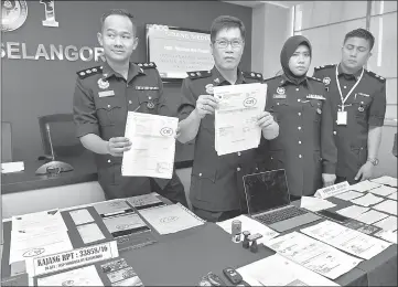  ??  ?? Mazelan (second left) showing the ‘delivery order’ documents. — Bernama photo