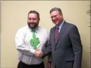  ?? CHAD FELTON — THE NEWS-HERALD ?? Morris Beverage III, wearing his “Cac-tie,” shakes hands with United Way of Lake County 2017 campaign chair Mark Sutherland at Beverage’s office in Mentor. Beverage’s “Dress up January” fundraiser raised $5,000 last year.