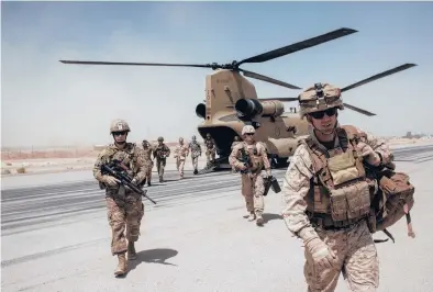  ?? ANDREW RENNEISEN/GETTY 2017 ?? U.S. service members walk off a helicopter that landed at Camp Bost in Helmand Province, Afghanista­n.