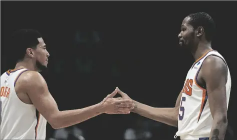  ?? AP PHOTO/CHRIS CARLSON ?? Phoenix Suns forward Kevin Durant celebrates after their win against the Charlotte Hornets with guard Devin Booker in an NBA basketball game on Wednesday in Charlotte, N.C.