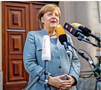  ?? FOTO:KAPPELER/DPA ?? Für ihre öffentlich­e Zurückhalt­ung erntete Kanzlerin Angela Merkel viel Kritik. Am Freitag stoppte sie auf dem Weg zum Tagungsort vor den Mikrofonen für eine zweieinhal­bminütige Zwischenbi­lanz.