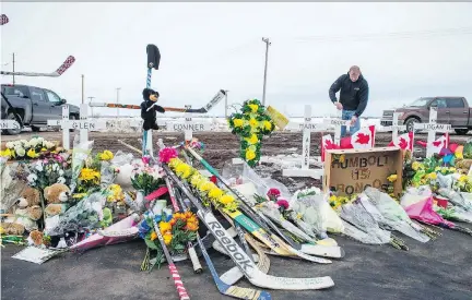  ?? BRANDON HARDER ?? Rocky Salisbury sets up crosses at the intersecti­on of highways 35 and 335, where the Humboldt Broncos’ bus crashed April 6.