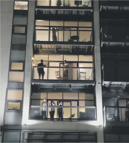  ?? PICTURE: ANDREW MILLIGAN/PA ?? 0 Glasgow residents take to their balconies to join in with the round of applause on 26 March