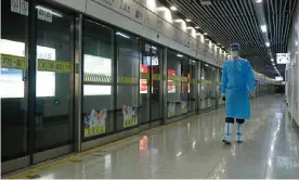  ?? Photograph: China News Service/Getty Images ?? A rail staff member in protective gear on duty at a subway station in Shanghai, China, as four of the city’s rail lines resumed service on Sunday amid the easing Covid lockdown.