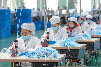  ?? WANG XIANG / XINHUA XUE YUGE / XINHUA ?? An automatic driving vehicle, remotely controlled by a technician, delivers packed meal boxes to employees at an industrial park in Changsha, Hunan province, in February.