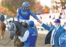  ?? Skip Dickstein / Hearst Newspapers 2020 ?? Trainer Brad Cox (right) congratula­tes jockey Luis Saez after winning the Breeders’ Cup Juvenile on Essential Quality.