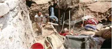  ?? File / Associated Press ?? ↑
Villagers salvage belongings from their collapsed house after heavy rain in Charsadda near Peshawar.