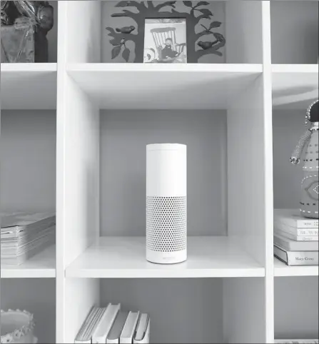  ?? LUKE MACGREGOR / GETTY IMAGES ?? An “Echo” device, center, stands on display in a set of shelves during the UK launch event for the Amazon.com Inc.