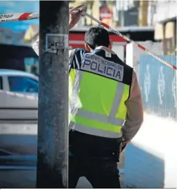  ?? JUAN CARLOS VÁZQUEZ ?? Un policía nacional cruza la zona acordonada del tiroteo.