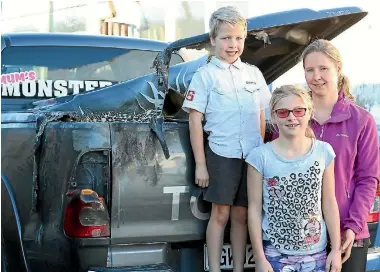  ?? PHOTO: TERESA RAMSEY/STUFF ?? Members of the Parrish family, of Paeroa, with their fire-damaged ute. From left, Charlie, 6, Amelia, 10, and Janine.