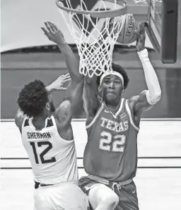  ?? BEN QUEEN/USA TODAY SPORTS ?? Texas forward Kai Jones drives baseline against West Virginia guard Taz Sherman on Saturday in Morgantown, W.Va.