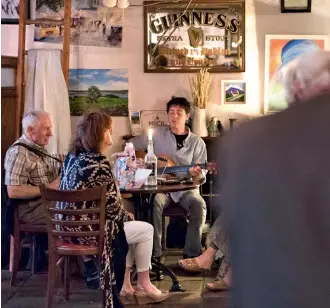  ??  ?? Musicians perform traditiona­l Irish songs at Powers Thatch Pub, in Oughterard.