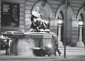  ?? Darrell Sapp/Post-Gazette ?? A snow-covered statue of Galileo seems to be watching as the sidewalk in front of the Carnegie Museum of Natural History along Forbes Avenue in Oakland is cleared of snow Friday morning.