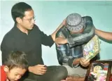  ?? MOKHAMAD ZUBAIDILLA­H/JAWA POS RADAR BROMO ?? SABAR YA, PAK: Nadiem menenangka­n Zubair, ayah Irza Almira, siswi SD yang meninggal akibat tertimpa atap kelas.