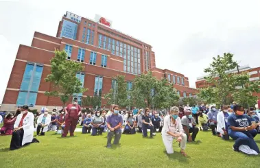  ?? PHOTOS BY JOE RONDONE/THE COMMERCIAL APPEAL ?? More than 200 members of hospital staff and medical workers take a knee outside Le Bonheur Children’s Hospital in Memphis to join in peace protests across the nation.