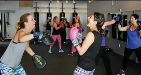  ?? MICHILEA PATTERSON — DIGITAL FIRST MEDIA ?? Lori Knight, left, and Marie Paone share a laugh during a boxing bootcamp class at the Ignite Fitness Studio in West Vincent. Paone said the cardio-intensive activity motivates her to take all the rest of the week.