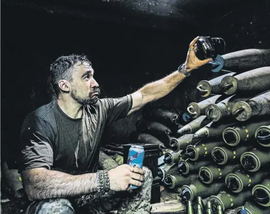  ?? Anadolu / Getty ?? Un soldado ucraniano preparando proyectile­s de artillería de 155 milímetros en el frente de la región de Donetsk, en agosto del 2023