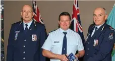  ??  ?? HERO: Senior Constable Brett Forte (centre) receives a service medal during his time at the Caboolture Police Station.