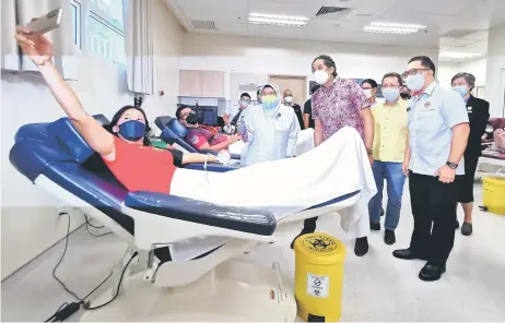  ?? — Photo by Roystein Emmor ?? A blood donor takes a wefie with Khairy (standing front, second le Shafiq and Dr Sim. ), hospital staff and other visitors at the SGH. Seen on the same row, from right, are Mohd