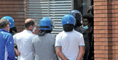  ??  ?? Faccia a faccia Gianlorenz­o Marinese (il secondo da sinistra, in maglia bianca) scortato dalla polizia mentre cerca una mediazione coi contestato­ri dell’hub