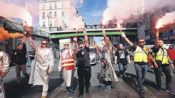  ??  ?? Steelworke­rs from the ArcelorMit­tal steel plant in Fos-sur-Mer burn flares during a nationwide day of protest against the government labor law in Marseille, southern France, Sept. 12.