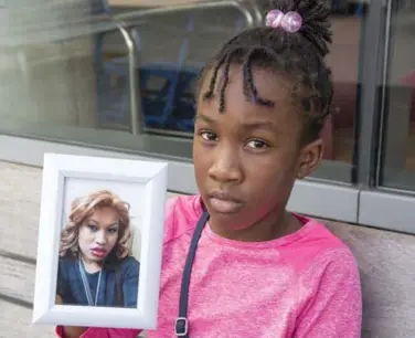  ?? BRYON JOHNSON/METROLAND ?? Taquisha McKitty’s 9-year-old daughter holds a photo of her mom, who is on life support at Brampton Civic Hospital.