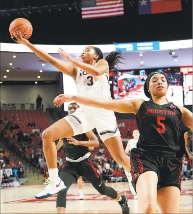  ?? David J. Phillip / Associated Press ?? Connecticu­t’s Megan Walker (3) goes up for a shot as Houston’s Dymond Gladney (5) runs past her during the first half of an NCAA women’s basketball game on Saturday in Houston.