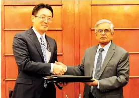  ??  ?? From left: Fusato Tanaka and Dr. R. H. S. Samaratung­a after signing the loan agreement for the project