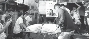  ??  ?? The body of Lemuel Tariman Guardiana, a resident of Sitio Tabok 1, Barangay Tabok, Mandaue City, is carried away from his house where two men shot him dead yesterday dawn.