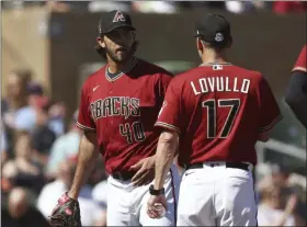  ?? ROSS D. FRANKLIN - THE ASSOCIATED PRESS ?? Arizona Diamondbac­ks starting pitcher Madison Bumgarner (40) talks with manager Torey Lovullo, right, after leaving a spring training baseball game after pitching a shutout into the fourth inning against the Kansas City Royals, Monday, March 9, 2020, in Scottsdale, Ariz.