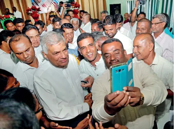  ??  ?? In an apparent bid to boost his campaign for the presidenti­al election, Prime Minister Ranil Wickremesi­nghe made an extensive four-day visit to the North. He is seen here allowing a supporter to take a selfie photograph.