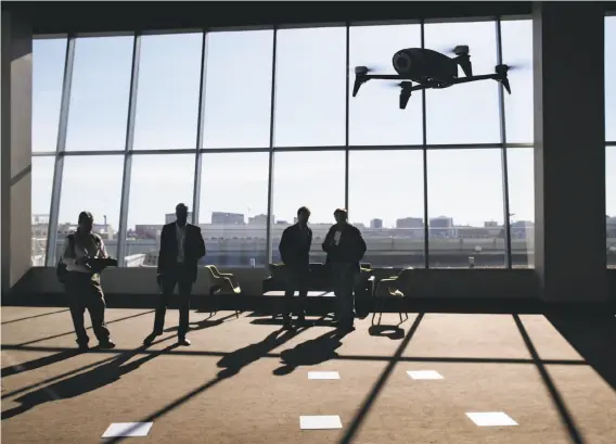  ?? Photos by Paul Chinn / The Chronicle ?? Guests take the Parrot Bebop Drone 2 for a test flight at a San Francisco news conference. The craft, available next month, is designed for shooting video.