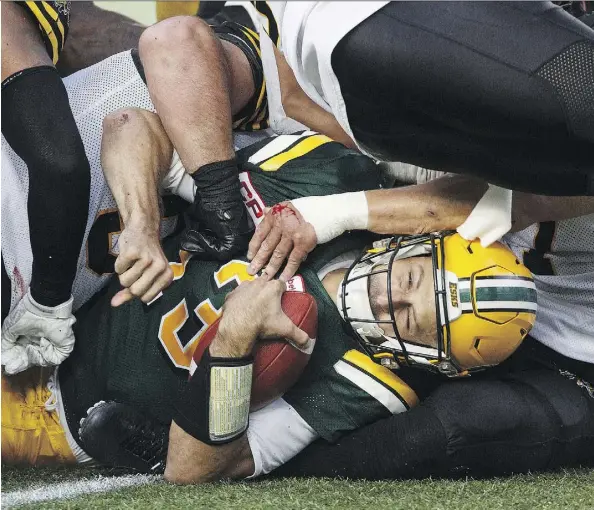  ?? THE CANADIAN PRESS ?? Mike Reilly, grounded on this play by the Tiger-Cats, engineered three long TD drives in the first half of Friday night’s win.