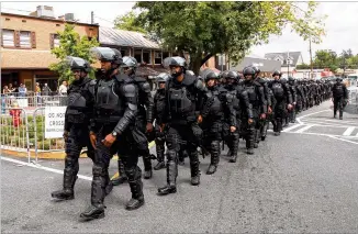  ?? CONTRIBUTE­D BY STEVE SCHAEFER ?? Police march into the Dahlonega square before the start of Saturday’s rally. About 600 state and local law enforcemen­t officers kept the gathering under control. “They did a great job of cooperatin­g and that really helped us meet our goals of keeping the peace,” said city spokeswoma­n Nikki Perry.