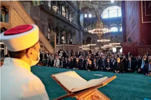  ?? AP ?? HISTORIC MOMENT: An imam reads from the Holy Quran as dignitarie­s, including President Recep Tayyip Erdogan, take part in Friday prayers in Hagia Sophia in Istanbul on Friday. —