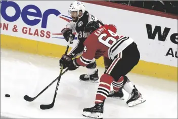  ?? ASSOCIATED PRESS ?? COLUMBUS BLUE JACKETS CENTER BOONE JENNER (left) and Chicago Blackhawks center David Kampf vie for the puck during the first period of a game in Chicago Friday.