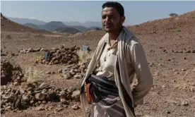  ?? Photograph: Sam Tarling/Sana’a Center ?? Trafficker Ahmad Dabisi in a makeshift migrant cemetery just outside Ataq, Shabwa Province, Yemen.