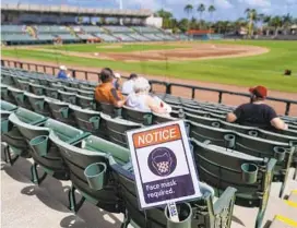  ?? BRYNN ANDERSON/AP ?? A sign requiring masks is seen in the seats during a spring training game between the Yankees and Orioles on Tuesday in Sarasota, Fla.