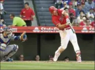  ?? MARK J. TERRILL — THE ASSOCIATED PRESS ?? Los Angeles Angels’ Mike Trout, right, hits a solo home run as Los Angeles Dodgers catcher Yasmani Grandal watches during the sixth inning of a baseball game Saturday, July 7, 2018, in Anaheim, Calif.