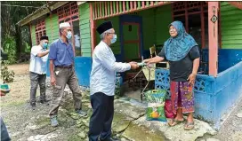  ??  ?? Relieving burden: Prof datuk dr Wahid Razzaly handing out duit raya to one of the villagers.