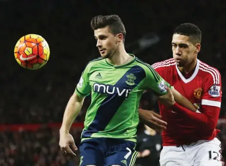  ?? ANDREW YATES/REUTERS ?? Southampto­n’s Shane Long holds off Manchester United’s Chris Smalling on Saturday at Old Trafford. Southampto­n won 1-0.