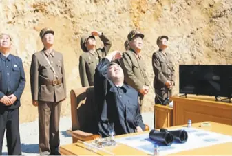  ?? North Korea KRT state television ?? In an image made from video of a news bulletin aired by North Korea’s KRT television, Kim Jong Un (center) is said to watch the launch of an interconti­nental ballistic missile on July 4.