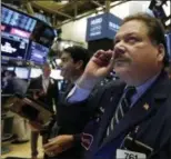  ?? RICHARD DREW — ASSOCIATED PRESS ?? Trader John Santiago, foreground, works on the floor of the New York Stock Exchange.