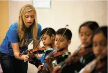  ?? Lea Suzuki / The Chronicle ?? Isabelle Gardner, 17, helps a student as she teaches violin to third-graders at Bahia Elementary School in San Rafael.