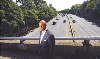  ?? AP PHOTO/JOHN AMIS ?? Tennessee State Rep. Harold Love Jr. stands on an overpass over I-40 on Monday near the site of his family’s former home on the north side of Nashville. Love’s father, a Nashville city councilman, was forced to sell his home to make way for the highway, but put up a fight in the 1960s against the rerouting of Interstate 40 because he believed it would stifle and isolate Nashville’s Black community. Love is now part of a group pushing to build a cap across the highway, behind him, that creates a community space to help reunify the city.