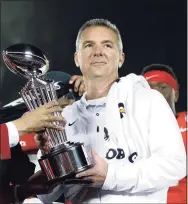  ?? Jae C. Hong / Associated Press ?? Ohio State coach Urban Meyer, right, holds the trophy after the team’s 28-23 win over Washington in the 2019 Rose Bowl.